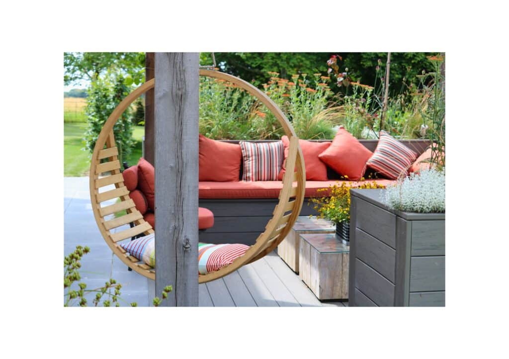 Seating surrounded by plants with coral-coloured cushions